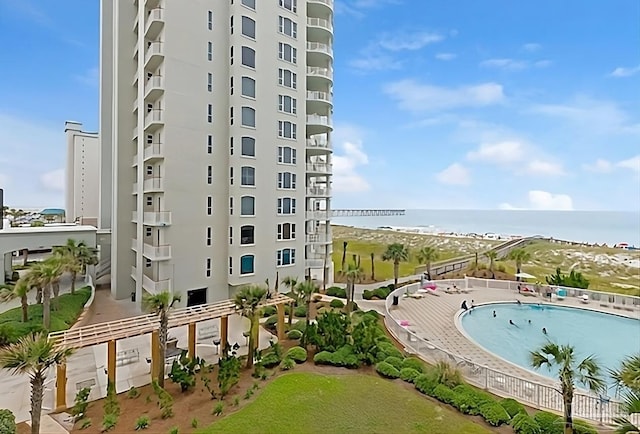 view of building exterior with a water view and a community pool