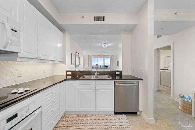 kitchen with white cabinetry, light tile patterned floors, decorative backsplash, sink, and white appliances