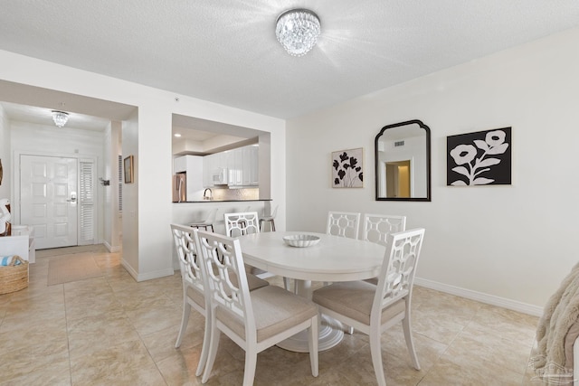 tiled dining area with a textured ceiling