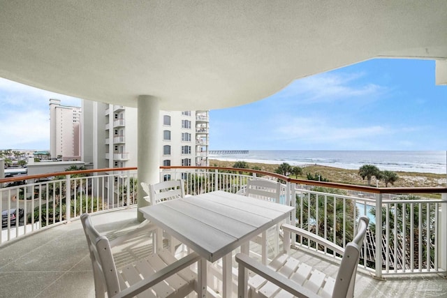 balcony featuring a view of the beach and a water view