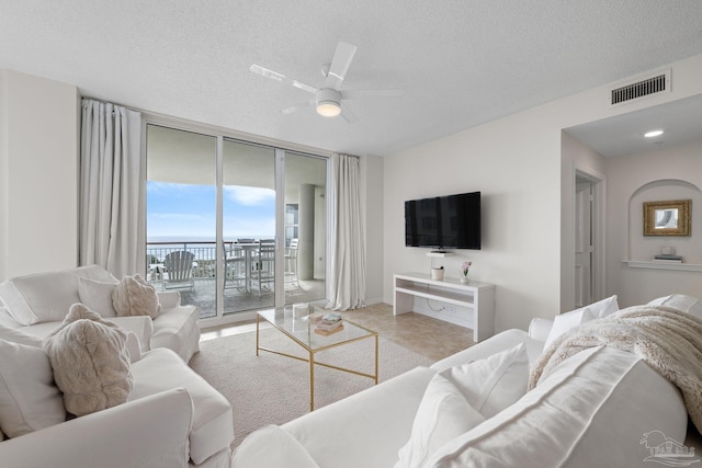 8501 Gulf Blvd Unit 3B, Navarre Beach, FL 32566 - living room with floor to ceiling windows, ceiling fan, a textured ceiling, baseboards, and tile patterned flooring