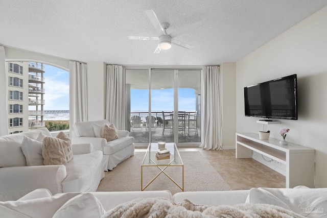 8501 Gulf Blvd Unit 3B, Navarre Beach, FL 32566 - living room with a textured ceiling, ceiling fan, floor to ceiling windows, baseboards, and light tile patterned floors