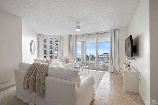 8501 Gulf Blvd Unit 3B, Navarre Beach, FL 32566 - living area with a ceiling fan, light tile patterned floors, baseboards, a textured ceiling, and floor to ceiling windows