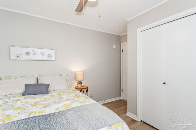 bedroom with ornamental molding, a closet, a textured ceiling, and wood finished floors