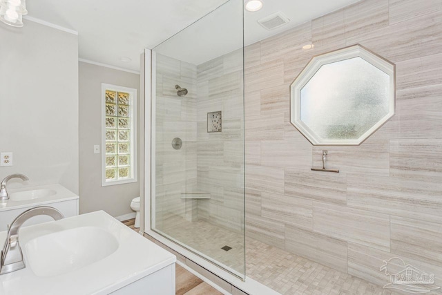 bathroom with vanity, visible vents, walk in shower, and ornamental molding