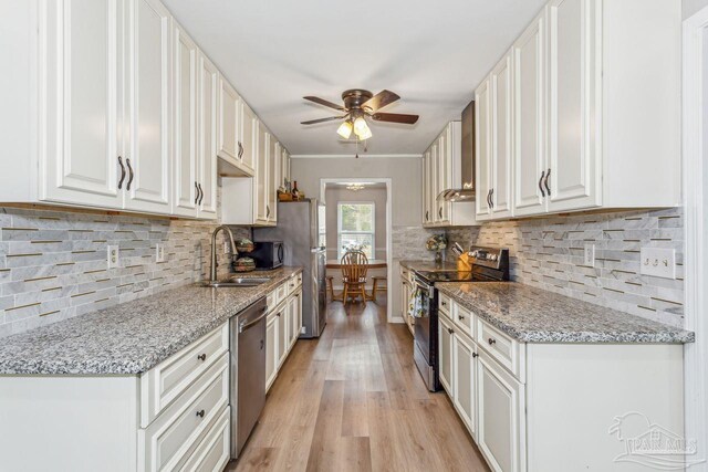 kitchen featuring ceiling fan, appliances with stainless steel finishes, a sink, and white cabinetry