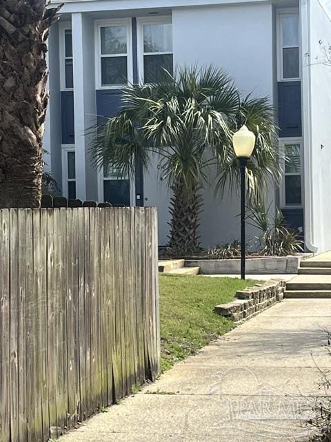 view of home's exterior with fence and stucco siding