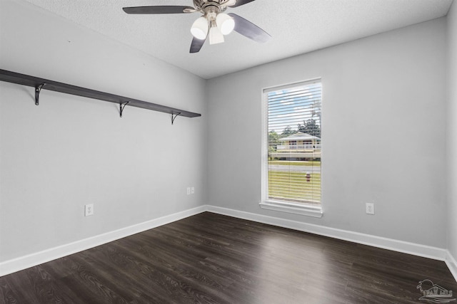 empty room with ceiling fan, baseboards, dark wood-style flooring, and a textured ceiling