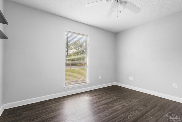 empty room with ceiling fan, baseboards, dark wood-type flooring, and a textured ceiling