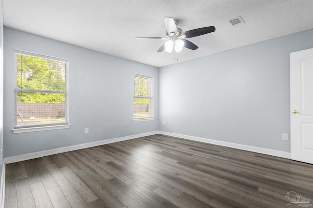 empty room with ceiling fan, baseboards, dark wood-style flooring, and visible vents