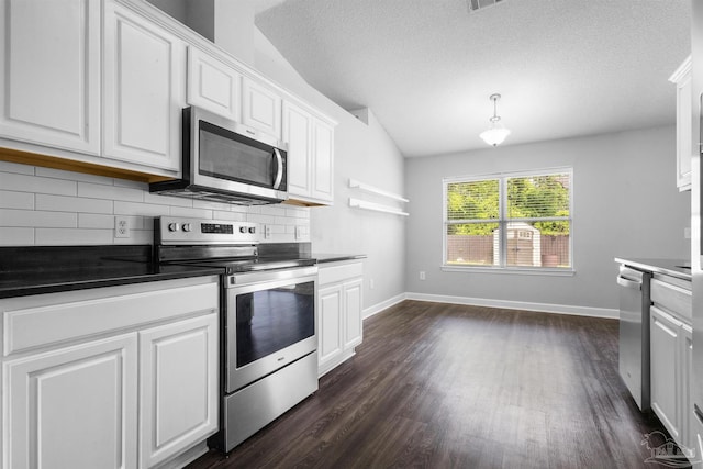 kitchen featuring dark countertops, appliances with stainless steel finishes, tasteful backsplash, and white cabinetry