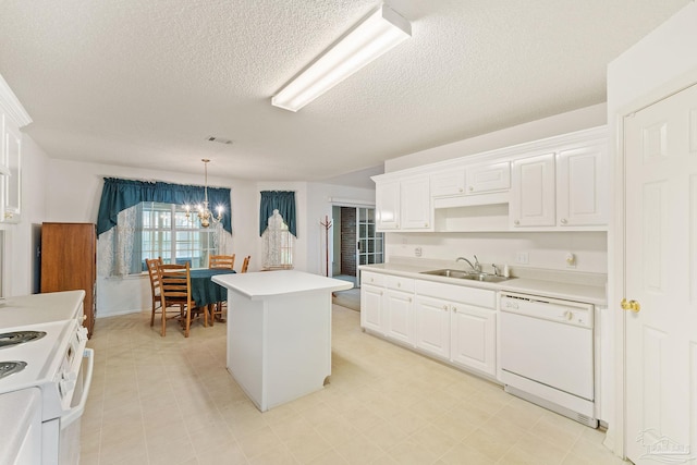 kitchen featuring a sink, white appliances, white cabinets, light countertops, and a chandelier