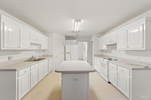 kitchen featuring white appliances, a kitchen island, a sink, under cabinet range hood, and white cabinetry