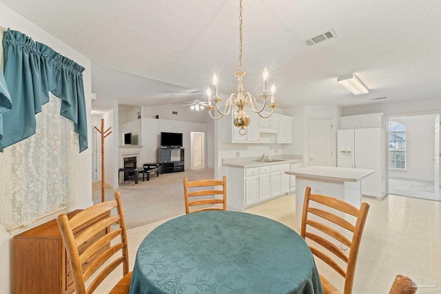 dining area with visible vents, light carpet, ceiling fan with notable chandelier, a textured ceiling, and lofted ceiling