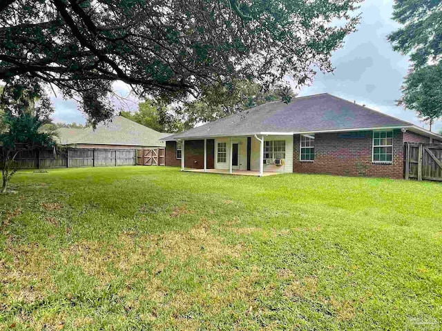 rear view of property featuring a patio area and a yard