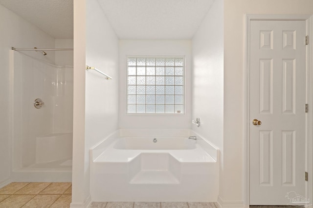 full bath with tile patterned floors, a bath, a shower, and a textured ceiling