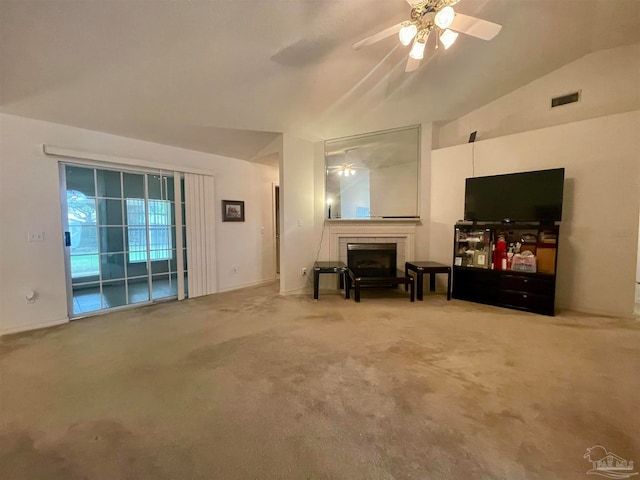 carpeted living room with ceiling fan, vaulted ceiling, and a brick fireplace