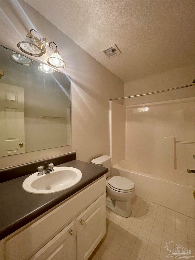 full bathroom featuring shower / tub combination, tile patterned flooring, toilet, vanity, and a textured ceiling