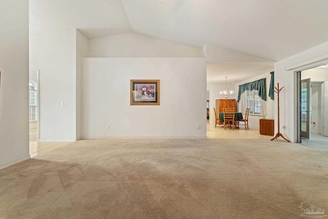 unfurnished room with carpet floors, a notable chandelier, and high vaulted ceiling