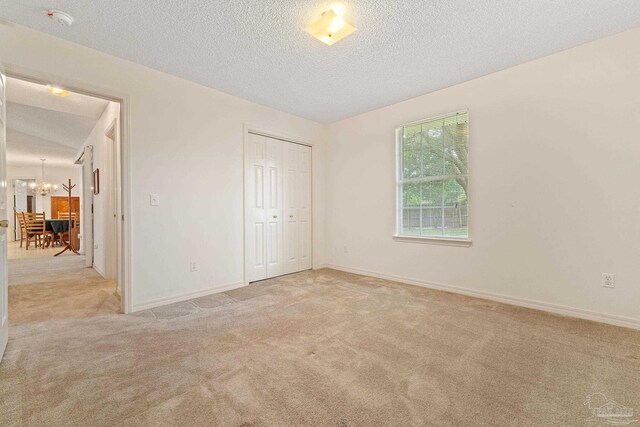 unfurnished bedroom featuring a closet, carpet, and a textured ceiling