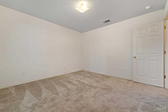 empty room with a textured ceiling and carpet floors