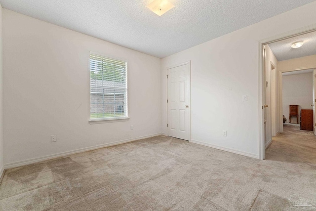 unfurnished bedroom featuring baseboards, carpet, and a textured ceiling