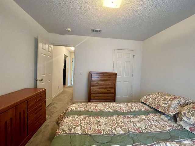 bedroom with a textured ceiling and carpet floors