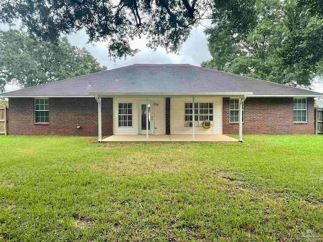 back of property with a lawn and a patio area