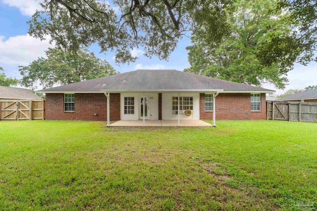 rear view of property with a patio area, a lawn, a fenced backyard, and a gate