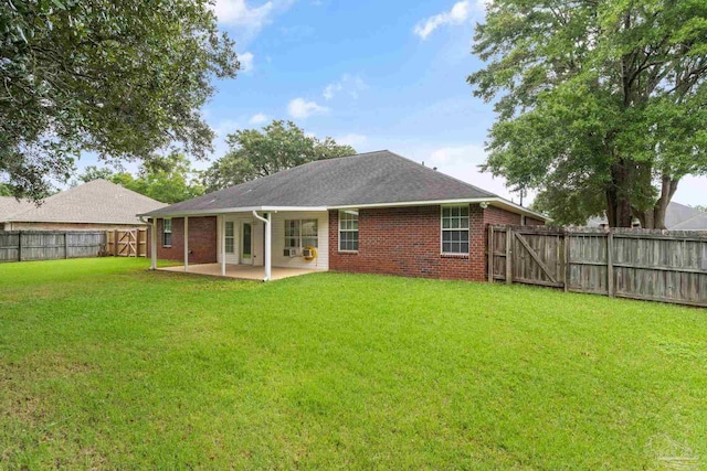 back of house featuring a patio area, a yard, and brick siding