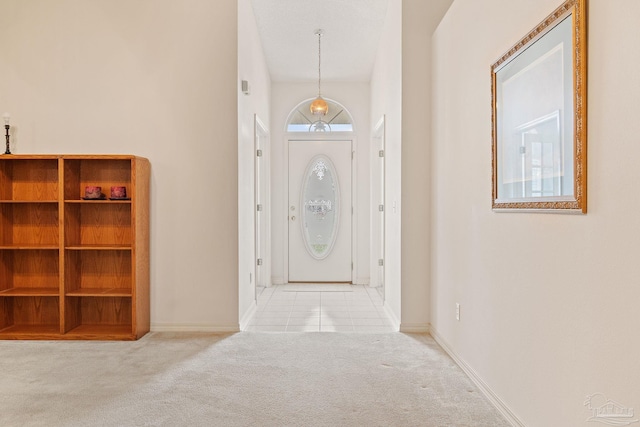 carpeted foyer entrance featuring baseboards