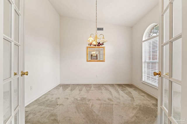 unfurnished room with baseboards, visible vents, carpet floors, and an inviting chandelier