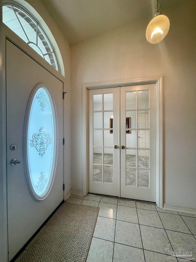 tiled foyer with french doors and vaulted ceiling