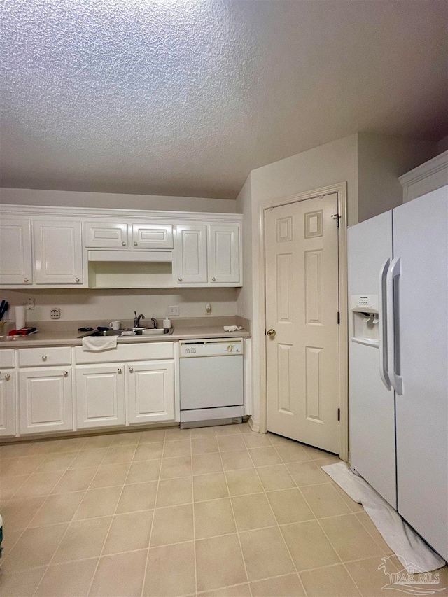 kitchen featuring light tile patterned floors, white appliances, white cabinetry, sink, and a textured ceiling