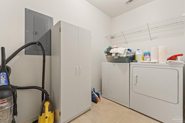 laundry area featuring electric panel, laundry area, light tile patterned flooring, a textured ceiling, and separate washer and dryer