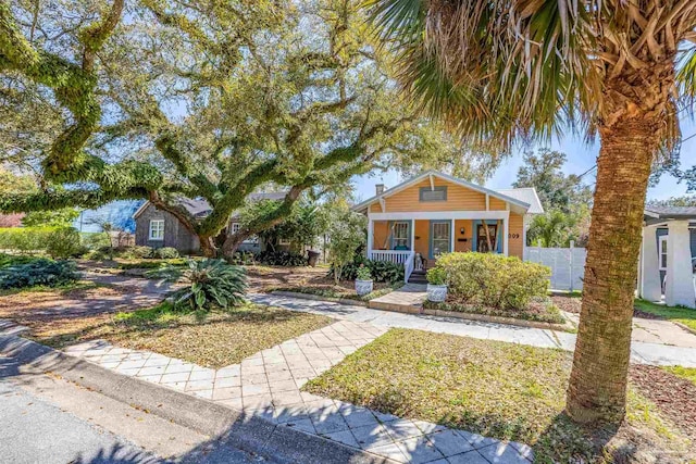 bungalow-style house featuring a porch and fence