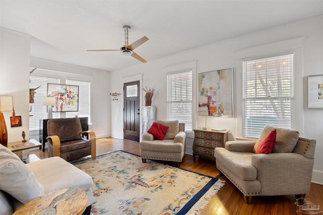 living area with a ceiling fan and wood finished floors