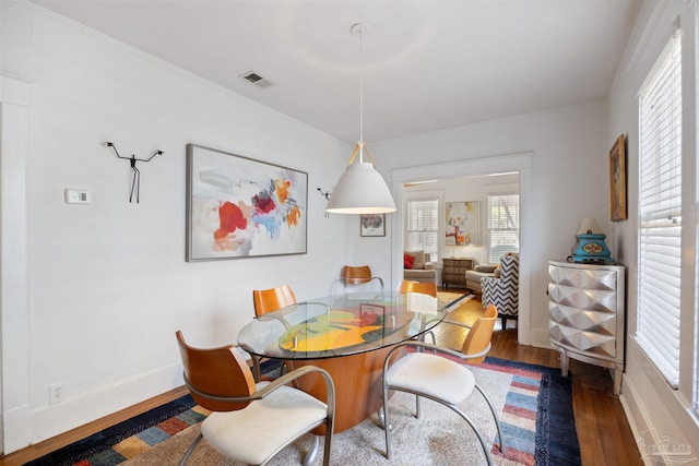 dining area featuring a wealth of natural light, visible vents, baseboards, and wood finished floors