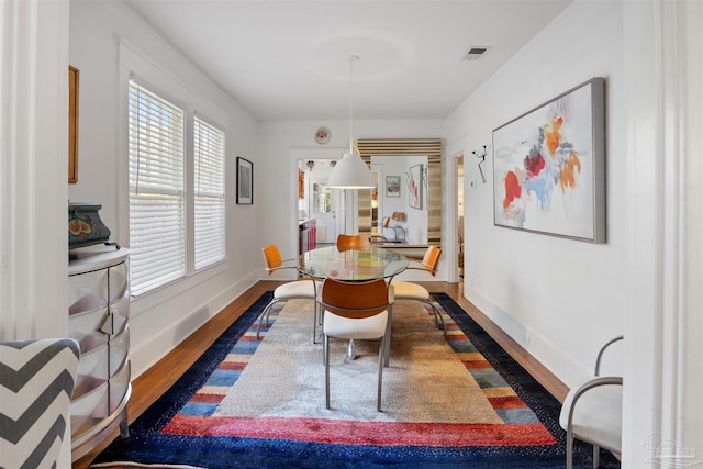 dining room featuring visible vents, baseboards, and wood finished floors