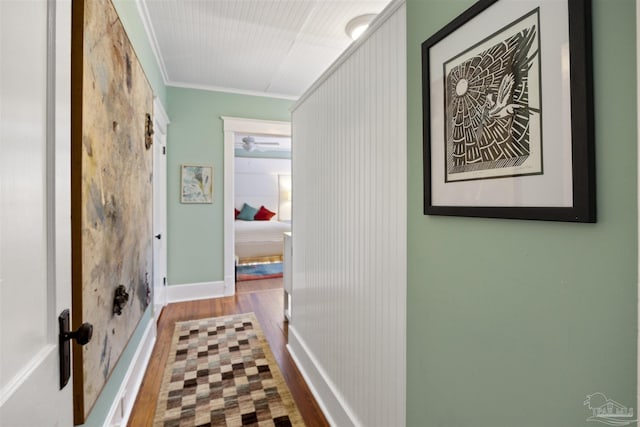 corridor featuring wood finished floors and ornamental molding