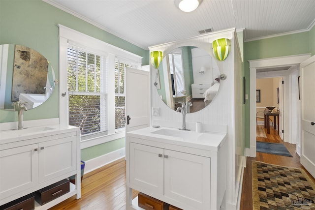 bathroom with wood finished floors, visible vents, and a sink