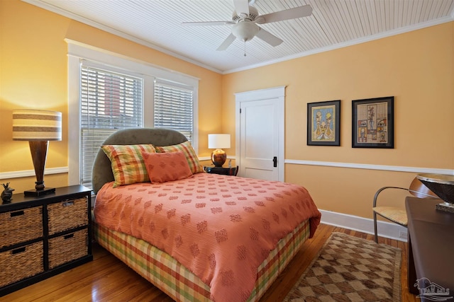 bedroom with ceiling fan, crown molding, baseboards, and wood finished floors