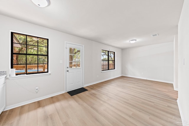 entrance foyer featuring baseboards, visible vents, and light wood-style flooring