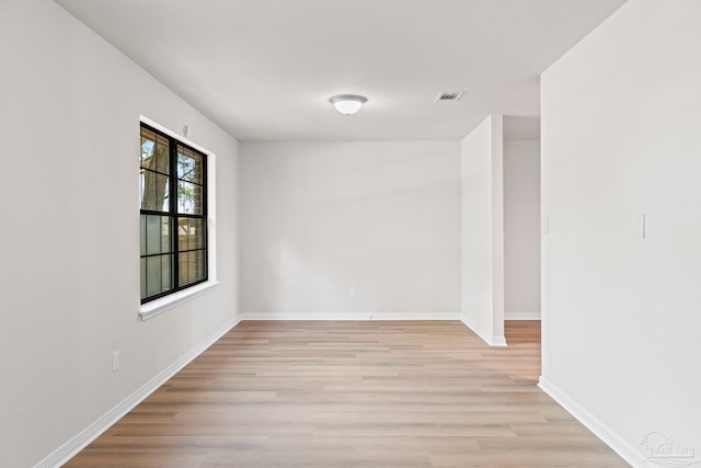 unfurnished room featuring visible vents, light wood-type flooring, and baseboards