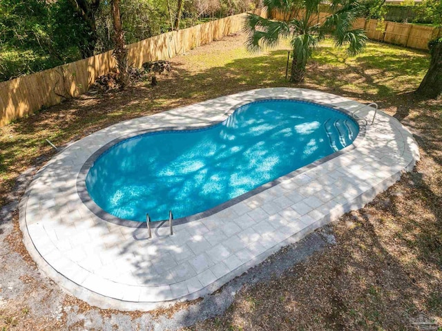 view of swimming pool featuring a yard and a fenced backyard