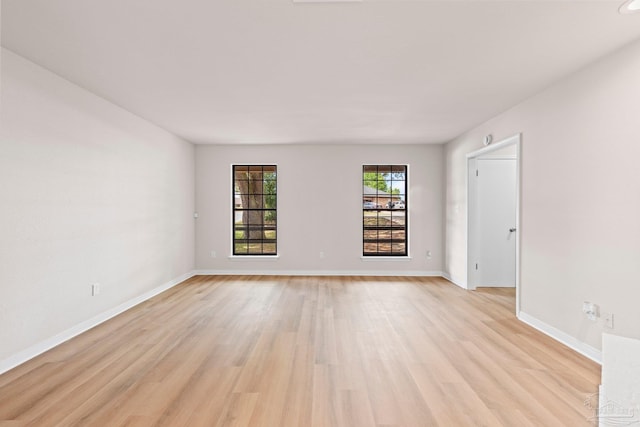 empty room with baseboards and light wood-style flooring