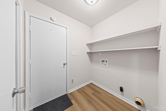 clothes washing area with wood finished floors, washer hookup, laundry area, and baseboards