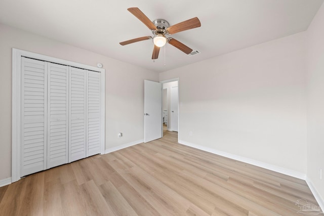 unfurnished bedroom with baseboards, visible vents, a closet, and light wood finished floors