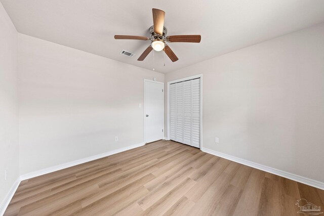 unfurnished room featuring baseboards, visible vents, a ceiling fan, and light wood-type flooring
