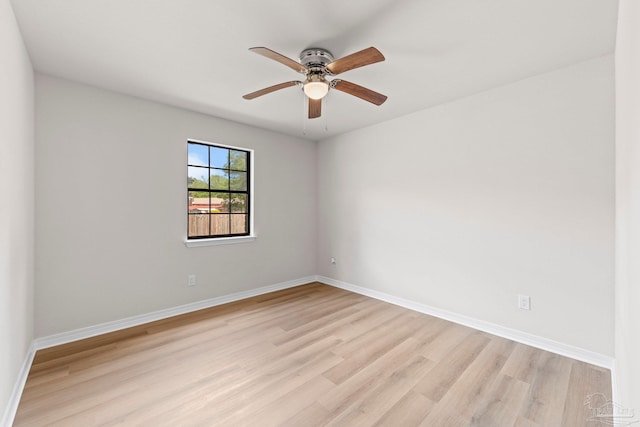 unfurnished room with a ceiling fan, light wood finished floors, and baseboards
